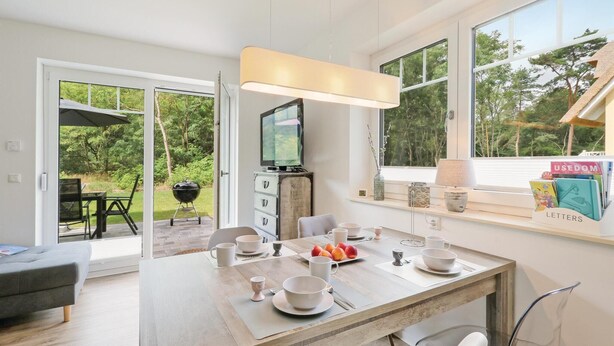 A modern kitchen with a dining area, large windows, and a view of the outdoors. - Reetdachhaus 20 auf Usedom (Zirchow/Usedom)