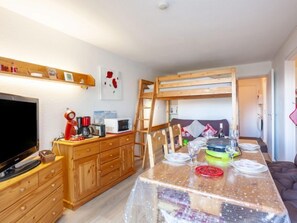 Une cuisine compacte avec des meubles en bois, un four à micro-ondes et une machine à café.