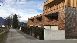 A modern building with a brick facade and wooden balconies. - Modern apartment with garden (Klaus)