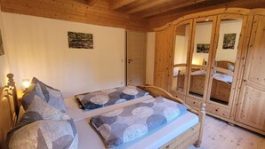 Dormitorio con dos camas, armario de madera y decoración en la pared.