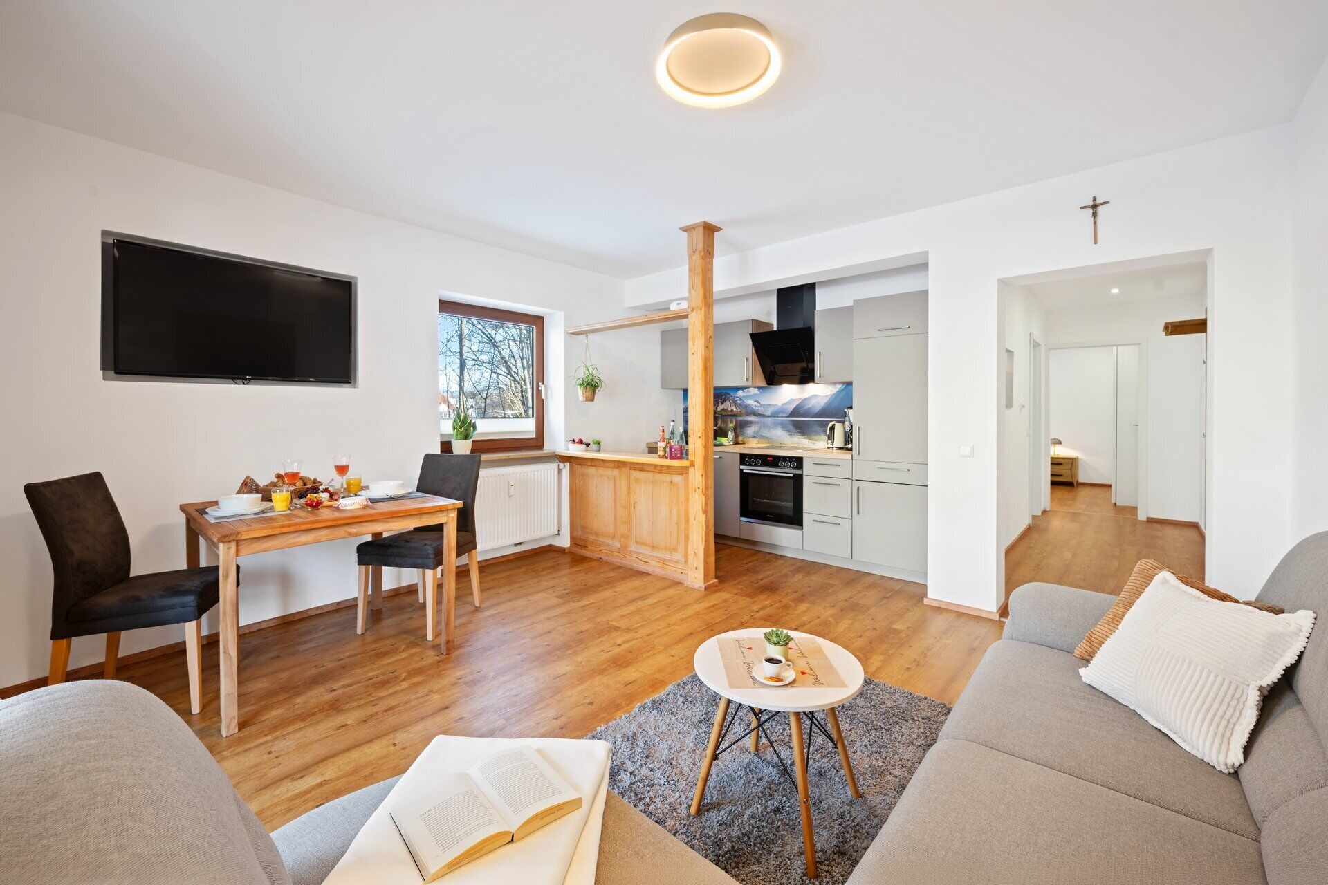 A modern living room with a sofa, a coffee table, and a dining area with a table and chairs.