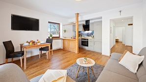 Un salon moderne comprenant un canapé, une table basse et un coin repas avec une table et des chaises.