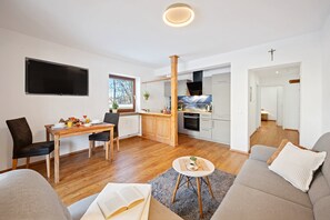 A modern living room with a sofa, a coffee table, and a dining area with a table and chairs. - Top location Bad Kohlgrub, first time use after complete conversion (Bad Kohlgrub)