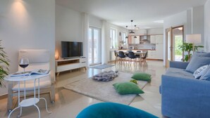 A modern living room with a TV, seating, and a dining area. - Vacation home Eugen by Interhome (Barban)