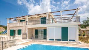 A two-story house with a swimming pool, balconies, and a view of the surrounding area. - Beautiful home in Zrnovnica-Split with sauna (Zrnovnica-Split)