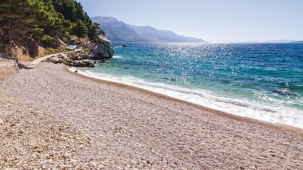 A pebble beach with a clear view of the sea and mountains in the background. - Beautiful home in Zrnovnica-Split with sauna (Zrnovnica-Split)