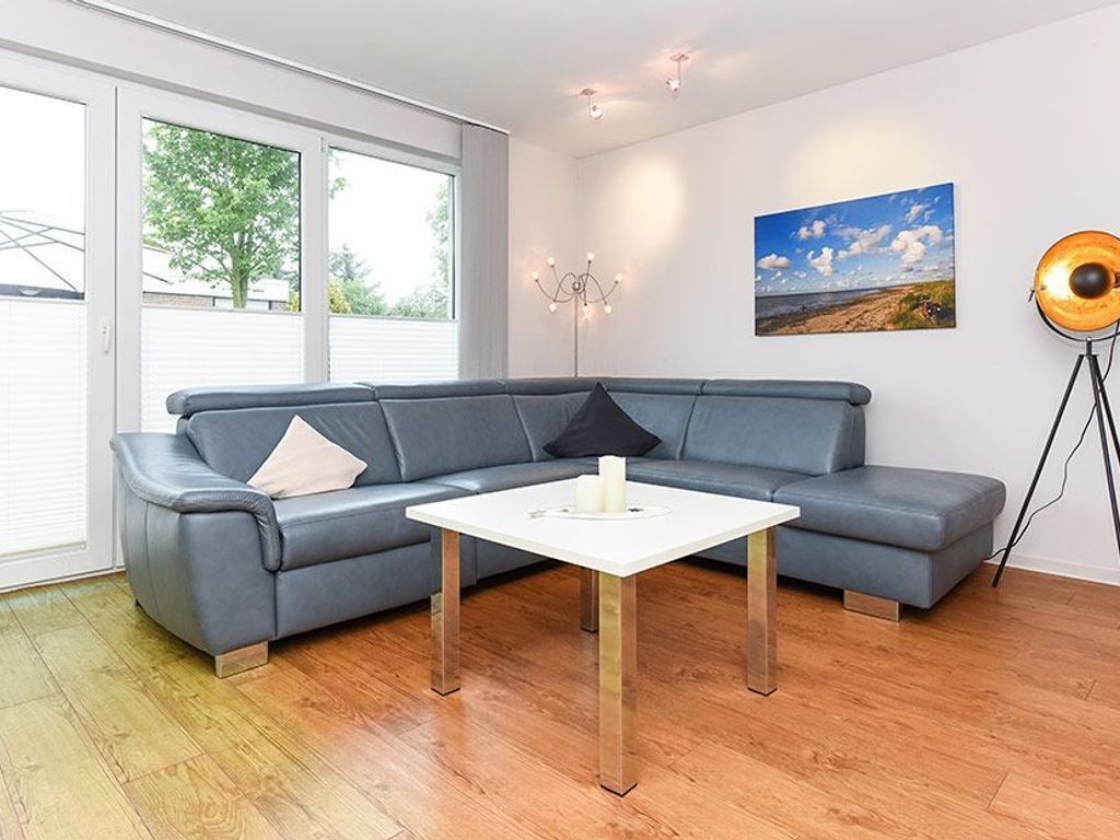 A modern living room with a grey sectional sofa, a white coffee table, and a floor lamp.
