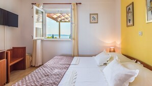 A bedroom with a bed, a window with curtains, a bedside table, and a lamp. - Villa Anima in Makarska, private pool (Makarska)