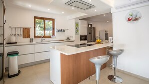 Una cocina moderna con una isla central, electrodomésticos de acero inoxidable y un ventanal que proporciona luz natural.