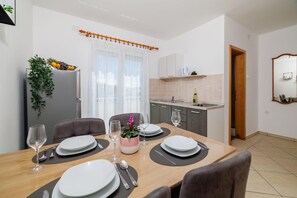 Enjoy meals in this dining area with a table for four, kitchenette, and a small window.