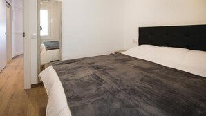 Une chambre à coucher avec un lit, une porte et un miroir.