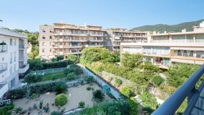 A residential building complex with multiple balconies, a courtyard with greenery, and a mountainous backdrop. - Côté Port by Interhome (Cavalaire)