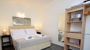 A neatly arranged bedroom with a bed, bedside tables, a mirror, and a wooden wardrobe. - Molo Lozna by Interhome (Brač/Postira)
