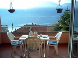 Enjoy a romantic meal on this balcony overlooking the serene mountainous landscape and tranquil body of water.