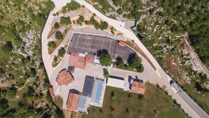 Vue aérienne d’un bâtiment doté d’un parking, de panneaux solaires et d’une allée d’accès incurvée.