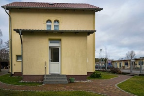 A two-story building with a yellow facade and a red-tiled roof. - Vacation apartment Kruggel 2 (Zinnowitz)