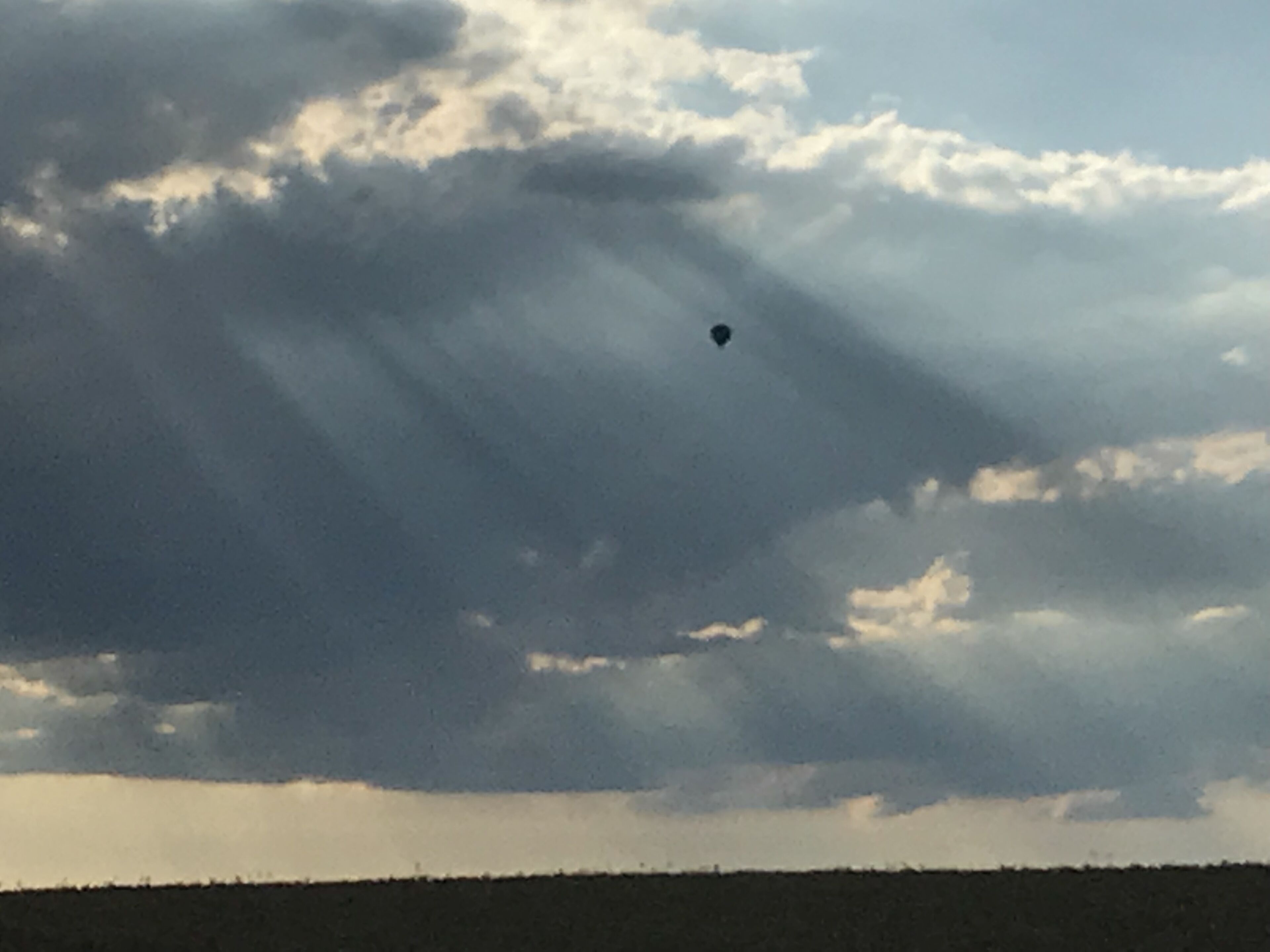 A landscape with a flat horizon and a cloudy sky.