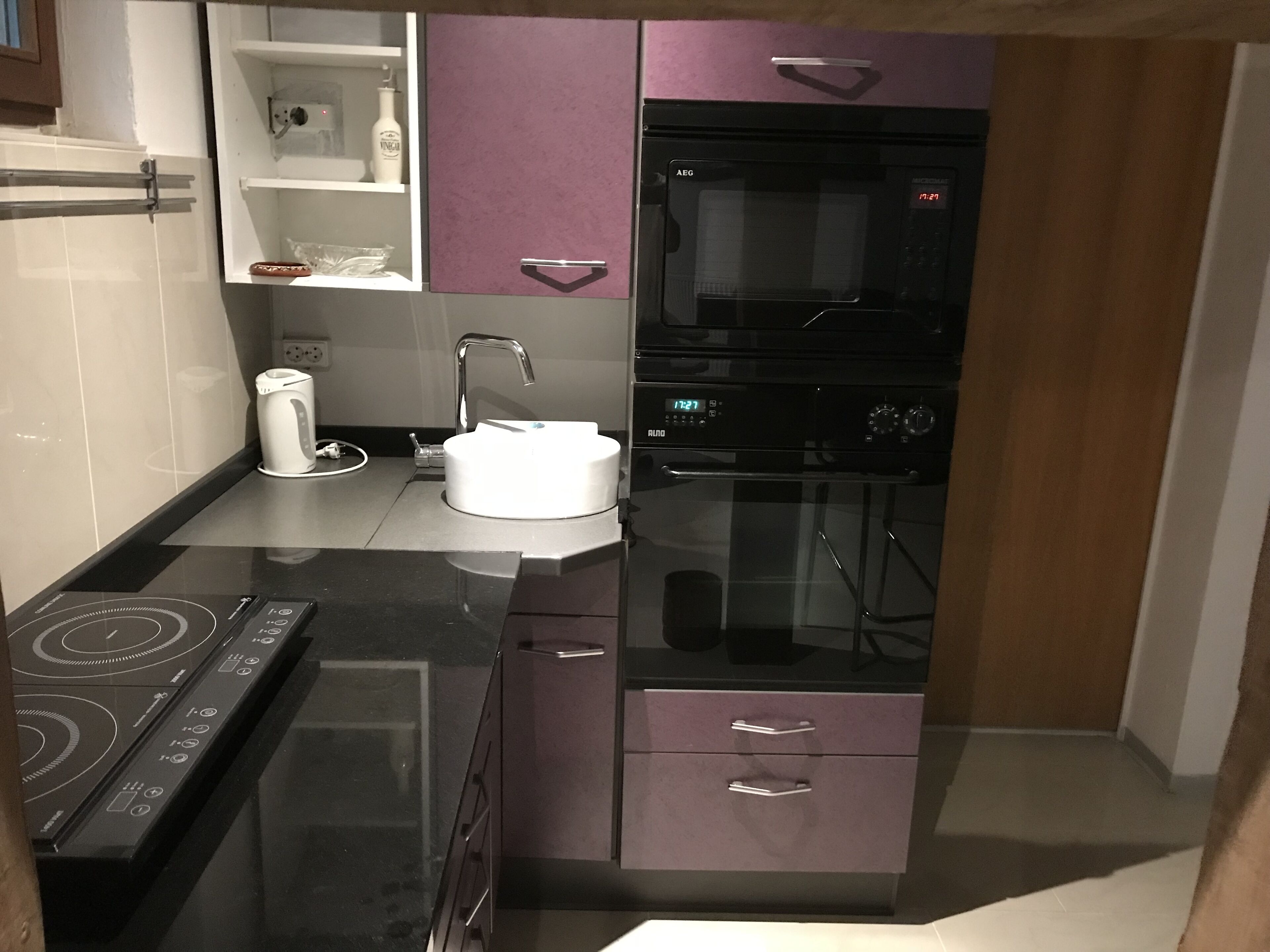 Une cuisine moderne équipée d’un four encastré, d’une plaque de cuisson et d’un évier.
