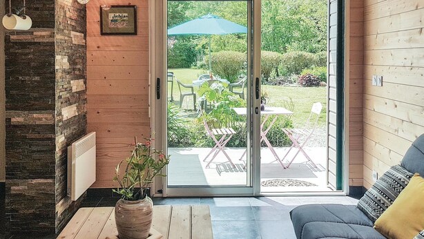 Een gezellige woonkamer met een bank, een bijzettafeltje en een plant in pot.