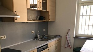 A kitchen with a stove, oven, sink, and cabinets. - Group accommodation Durbach (Durbach)