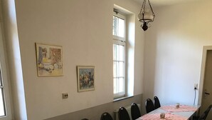 A long dining table with chairs, a chandelier, and artwork on the walls. - Group accommodation Durbach (Durbach)
