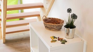 Une console blanche, ornée d’un panier tressé, d’une plante en pot et de petites figurines de poissons décoratives.