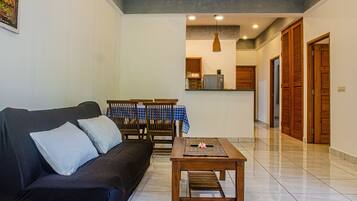 Departamento Deluxe, 2 habitaciones, cocina, vista a la alberca | Área de sala de estar | Televisión