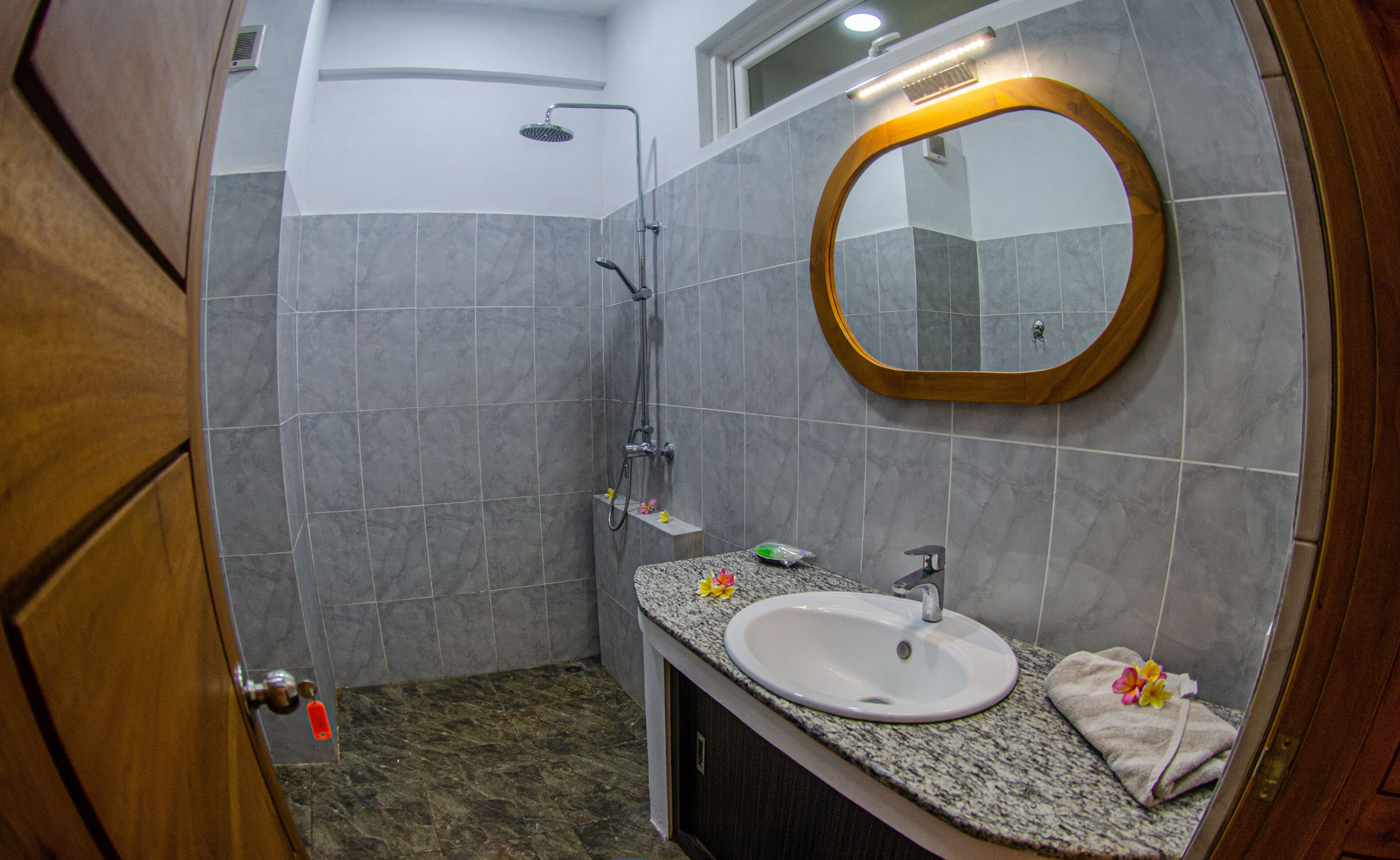 A bathroom with a shower, a sink, and a mirror.