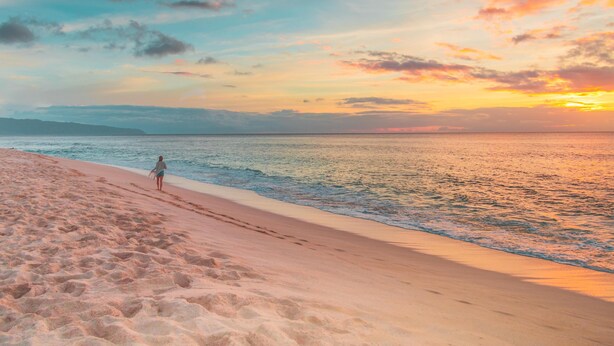 A beach with a person walking along the shore. - Senggigi Homes & Apartments (Senggigi)