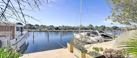 A marina with boats docked, a clear sky, and a calm water body.