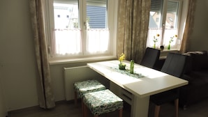 Un comedor con una mesa, dos sillas y dos bancos iguales.