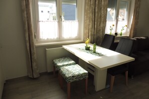 Uma área de refeições com uma mesa, duas cadeiras e dois bancos combinando.
