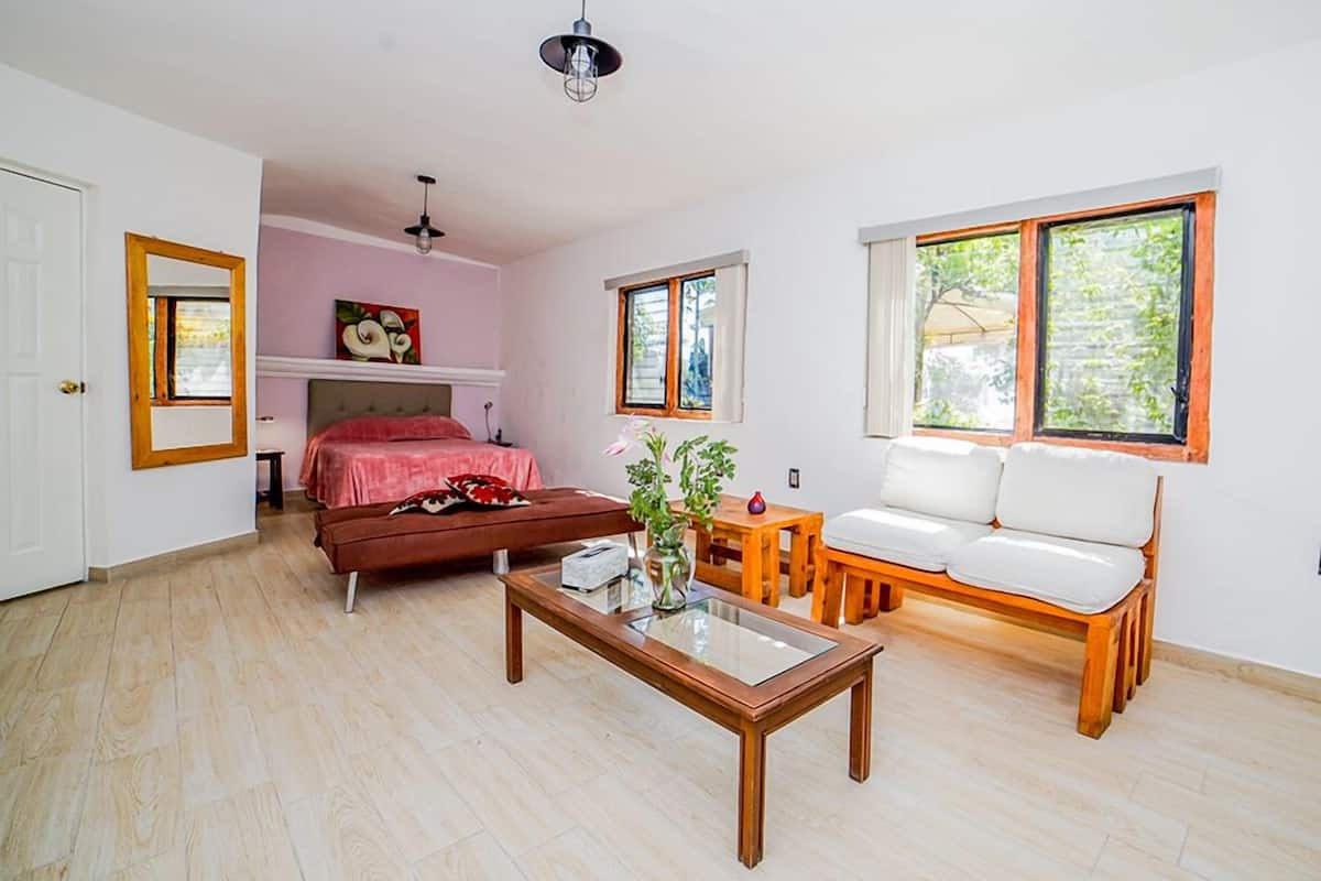 Une chambre à coucher avec un lit, une table de chevet et une fenêtre.