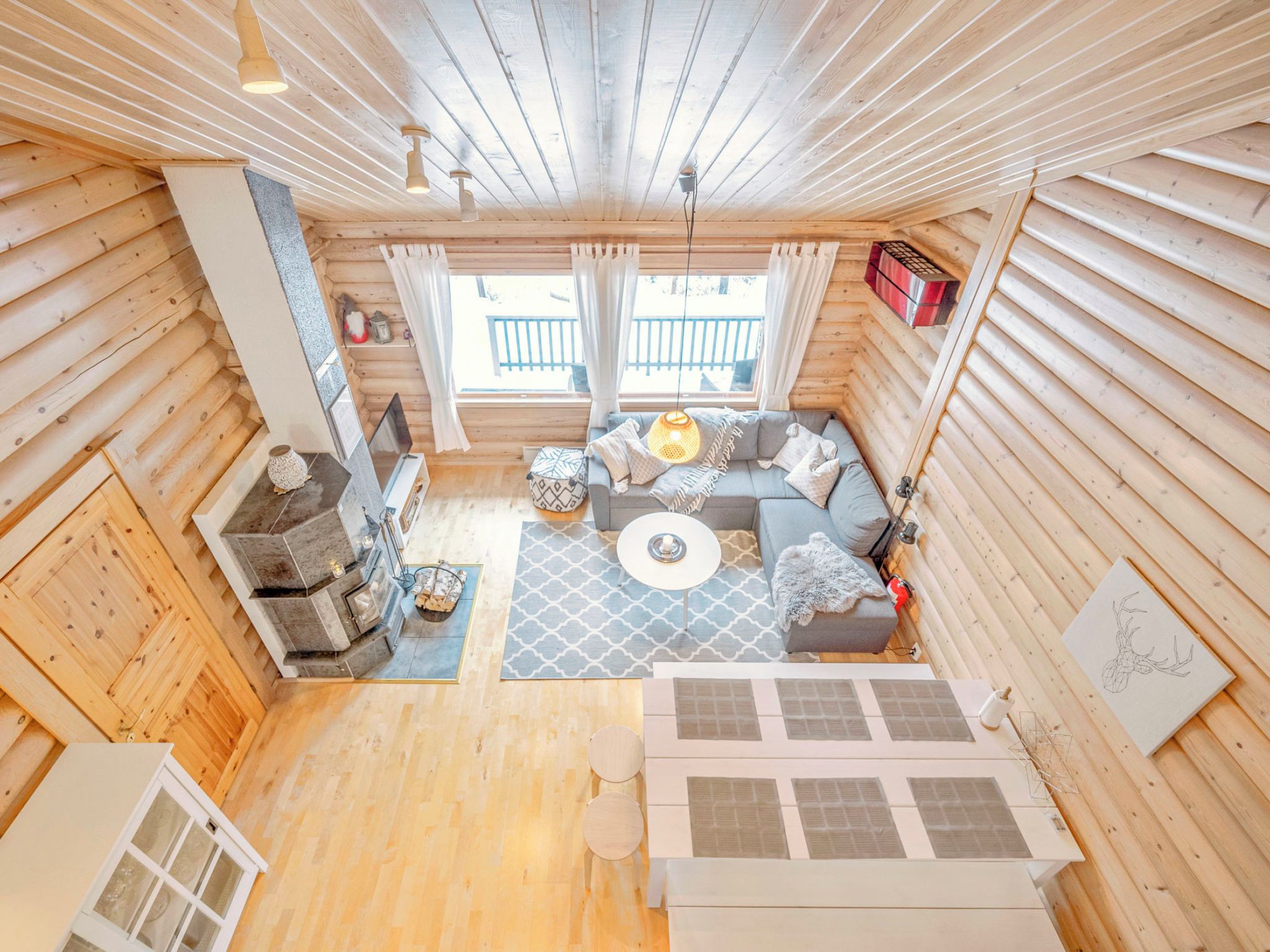 Interior acogedor de una cabaña de madera con un conjunto de sofás, una chimenea y un comedor.