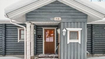 A wooden cabin with a front door, a mailbox, and a number '78' sign.