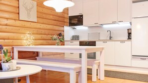 A modern kitchen with white cabinets, a built-in oven, and a microwave. - Vacation home Aino by Interhome (Kuusamo)