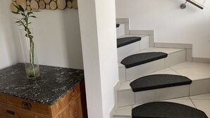 A staircase with black carpeted steps and a metal handrail.