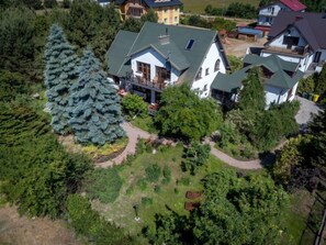 Ett bostadsområde med hus, ett stort barrträd och en välskött trädgård.