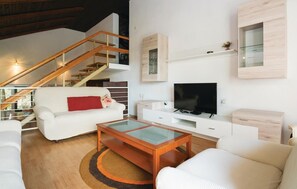 Relax in this stylish living room with a sofa, coffee table, and flat-screen TV.