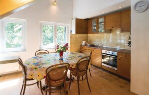 Enjoy meals in this kitchen with a sink, stainless steel oven, and dining area with a table and chairs.