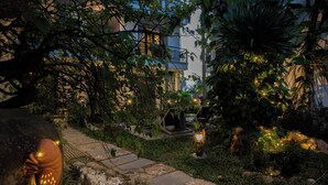 A garden pathway with stone tiles, surrounded by lush greenery and decorative lighting. - Fairy Garden Villa (Da Nang)