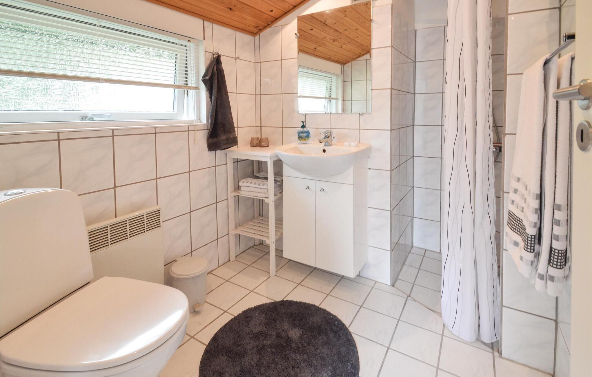 A bathroom with a toilet, sink, and shower.
