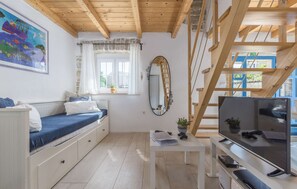 A cozy room with a bed, a TV, a mirror, and a window with curtains. - Holiday House Natura - pure relaxation for six guests with a private pool by MyWaycation (Rajki)