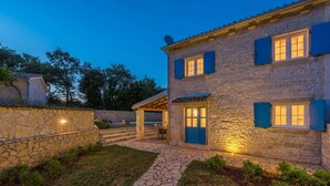 A stone building with a stone pathway leading to a covered patio area.