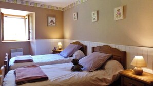 A bedroom with two beds, a window, and wall decorations. - Gîte de Fontainebleau (Vicdessos)