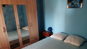 A bedroom with a bed, a nightstand, a lamp, and a wardrobe. - Holiday rental in Gard near Anduze (Boisset-et-Gaujac)