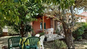 An outdoor seating area with green and white plastic chairs, a table, and potted plants. - Holiday rental in Gard near Anduze (Boisset-et-Gaujac)