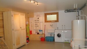 Un cuarto de lavado con lavadora, secadora, lavamanos y calentador de agua.