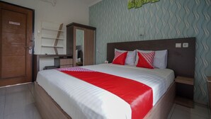 A hotel room with a bed, a wardrobe, a mirror, and a wall with a wavy pattern. - Hotel O Green Palm Kostel Syariah (Lubuklinggau)