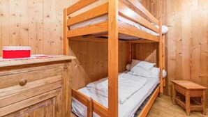 A bunk bed room with wooden walls, a small desk, and a red box on the desk. - The charm of an alpine chalet, an ideal location for sport and shopping (Mont-de-Lans)
